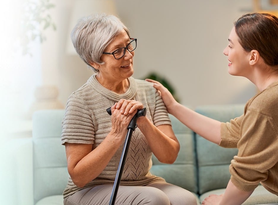 Compassionate Abriva caregiver helping an elderly man at home in Minnesota
